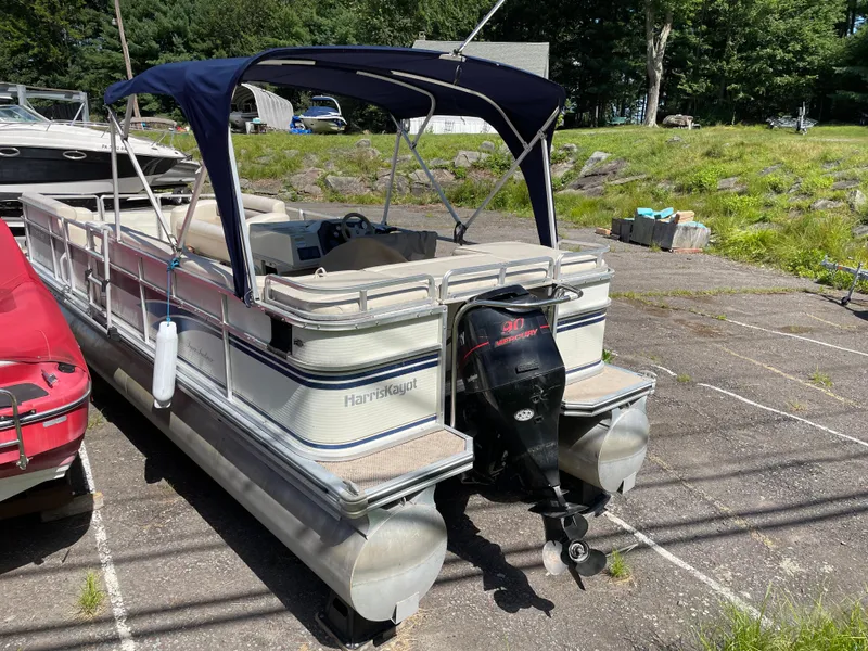Slide: The Image of 1999 Harris Sunliner 240 pontoon boat with Mercury 90 outboard motor, parked outdoors. - 9