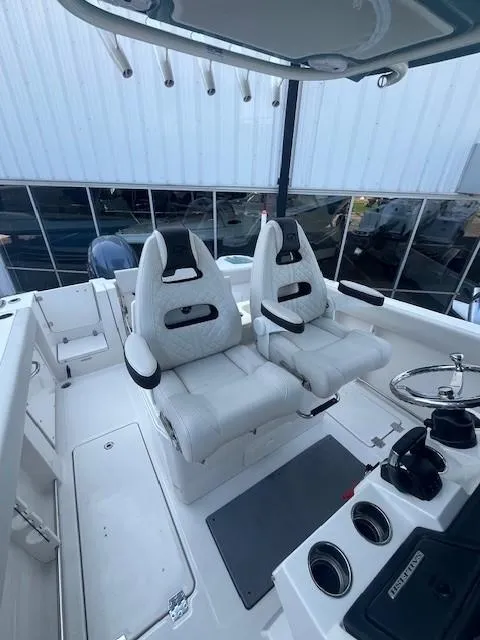 Slide: The Image of 2023 Sailfish 272 CC boat interior with dual white captain's chairs and steering console. - 10