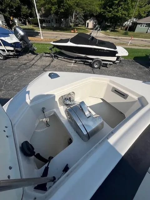 Slide: The Image of 2023 Sailfish 272 CC boat anchor compartment, parked on a trailer in a sunny outdoor setting. - 15