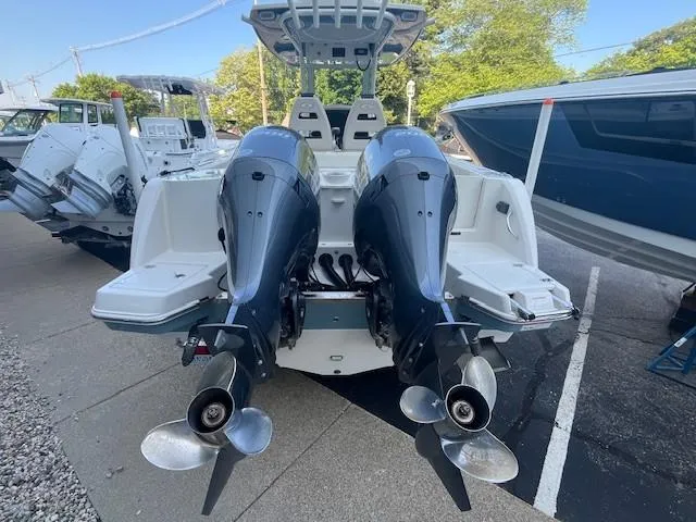 Slide: The Image of 2023 Sailfish 272 CC boat with dual outboard motors, docked in a marina. - 4