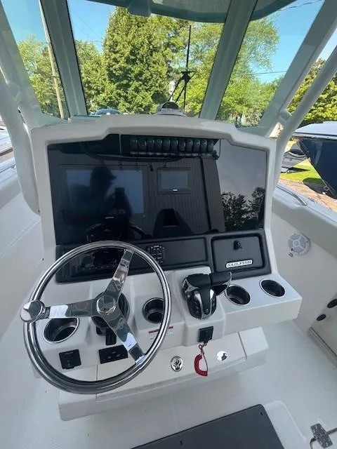 Slide: The Image of 2023 Sailfish 272 CC boat dashboard with steering wheel and control panel. - 7