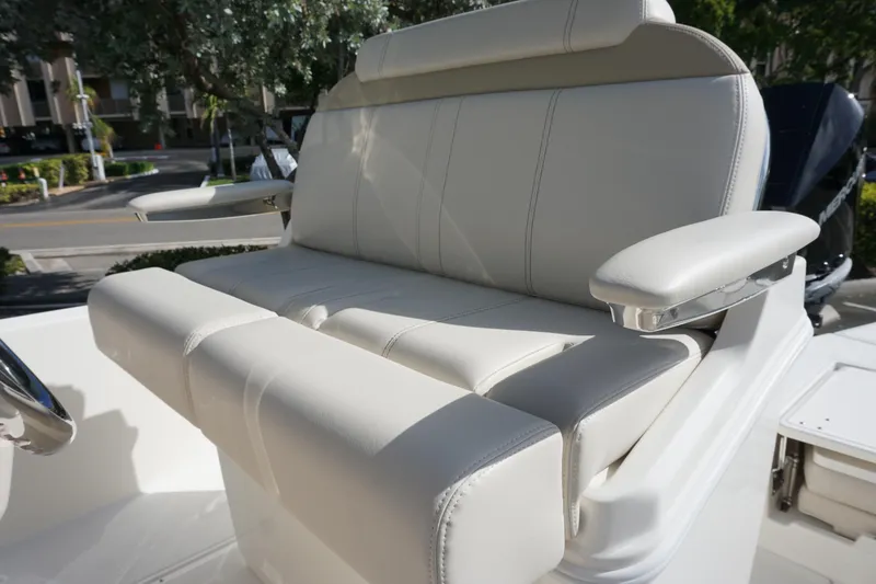 Slide: The Image of 2026 Boston Whaler 250 Dauntless boat seat with armrests, white upholstery, outdoor setting. - 10