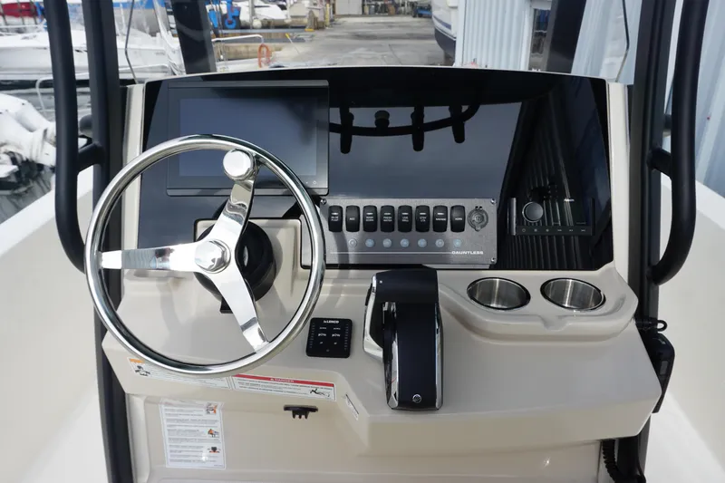 Slide: The Image of 2026 Boston Whaler 250 Dauntless helm with steering wheel and control panel. - 11