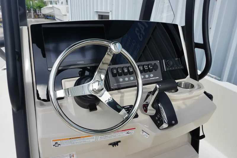 Slide: The Image of 2026 Boston Whaler 250 Dauntless helm with steering wheel and control panel. - 12
