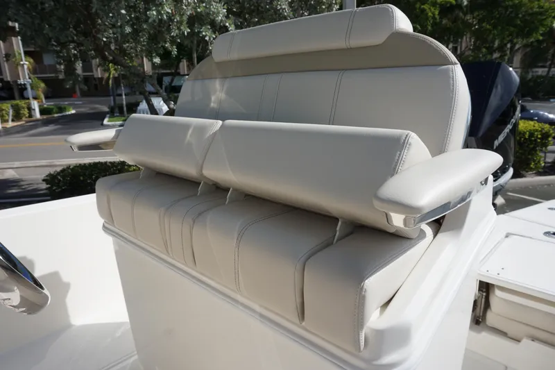 Slide: The Image of 2026 Boston Whaler 250 Dauntless boat seat with armrests, outdoor setting. - 9