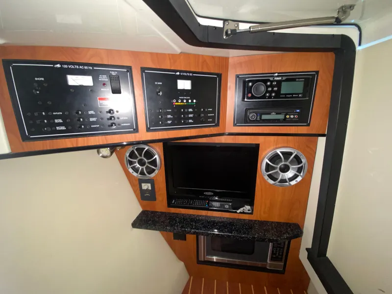 Slide: The Image of Control panel and entertainment system inside a 2012 Monterey 328SS boat cabin. - 13