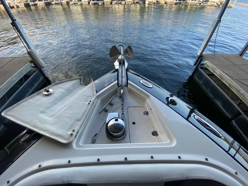 Slide: The Image of Bow of 2012 Monterey 328SS boat docked at marina, featuring anchor and storage compartment. - 26