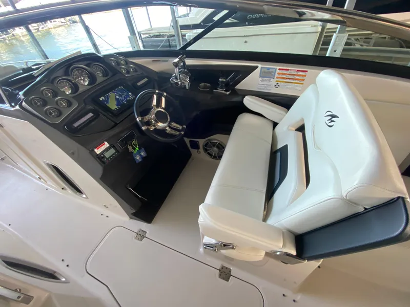 Slide: The Image of 2012 Monterey 328SS boat cockpit with steering wheel, gauges, and white captain's chair. - 32