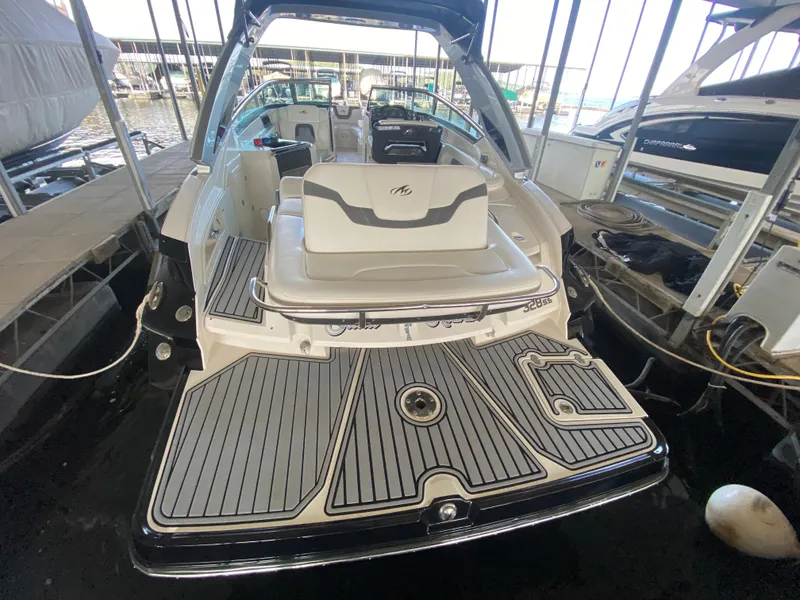 Slide: The Image of 2012 Monterey 328SS boat with spacious deck and seating, docked in a marina. - 37