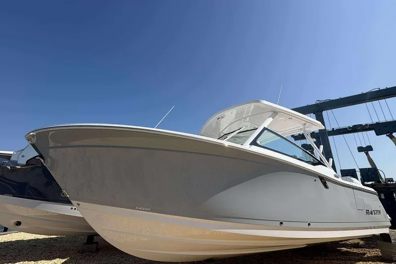 The Image of 2026 Blackfin 272 DC boat under clear blue sky, side view. - 0