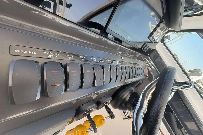 Slide: The Image of Control panel of 2026 Blackfin 272 DC boat with labeled switches and steering wheel. - 11