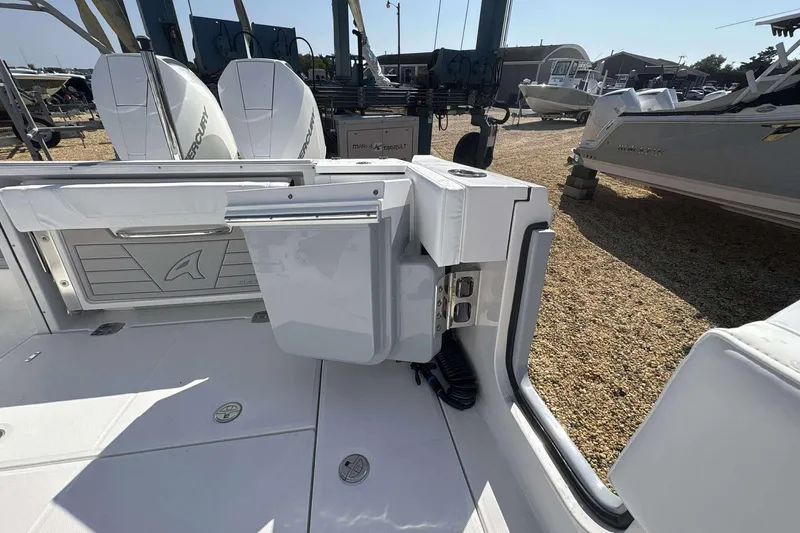 Slide: The Image of 2026 Blackfin 272 DC boat interior with Mercury engines, docked on gravel. - 15