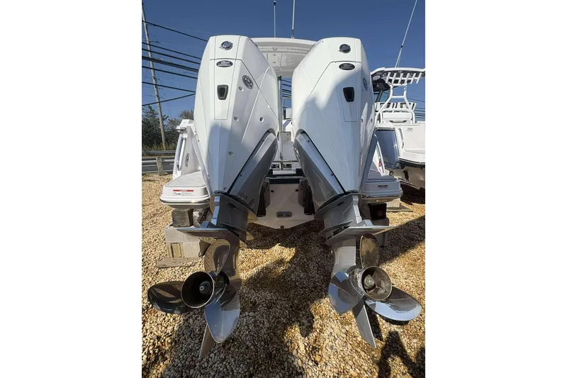 Slide: The Image of 2026 Blackfin 272 DC boat with dual outboard engines, displayed on gravel. - 26
