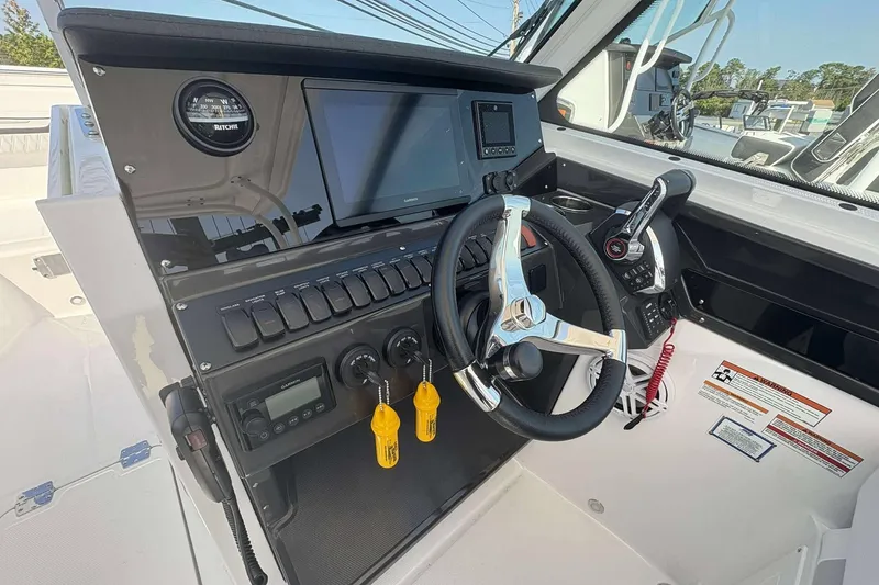 Slide: The Image of 2026 Blackfin 272 DC boat dashboard with steering wheel and navigation controls. - 9