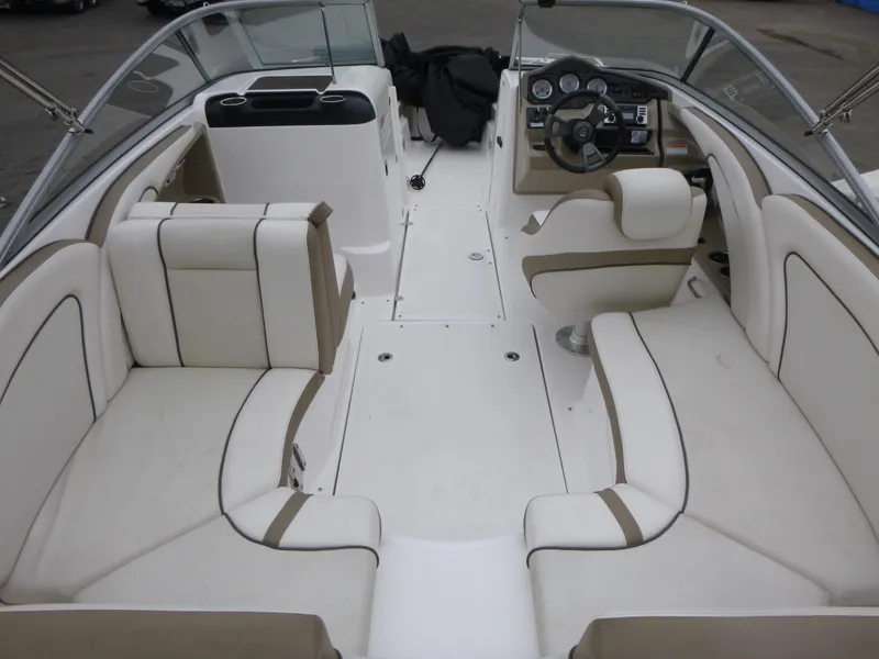 Slide: The Image of 2013 Yamaha Boats SX240 HO interior with white and beige seating, steering wheel, and dashboard. - 4