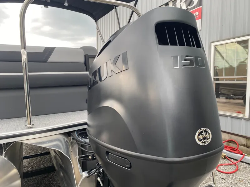 Slide: The Image of 2025 Berkshire 22 CL2 pontoon boat with Suzuki 150 outboard motor, docked near a building. - 8