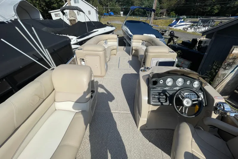 Slide: The Image of 2010 Harris Grand Mariner 240 pontoon boat interior with beige seating and control panel. - 12