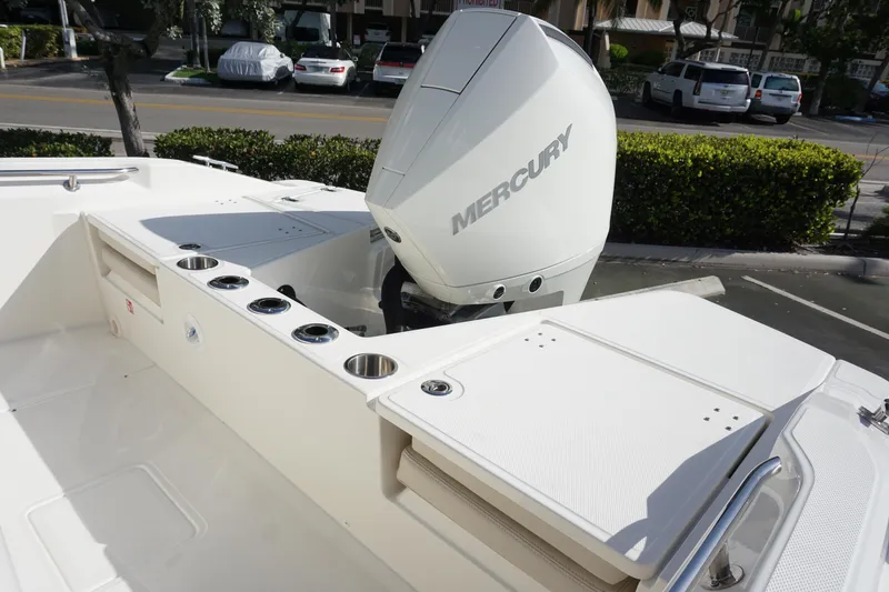 Slide: The Image of 2026 Boston Whaler 220 Dauntless boat with Mercury engine, featuring rod holders and storage. - 11