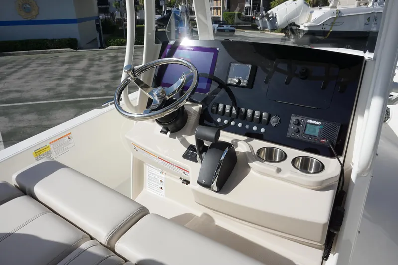 Slide: The Image of 2026 Boston Whaler 220 Dauntless boat console with steering wheel and controls. - 16