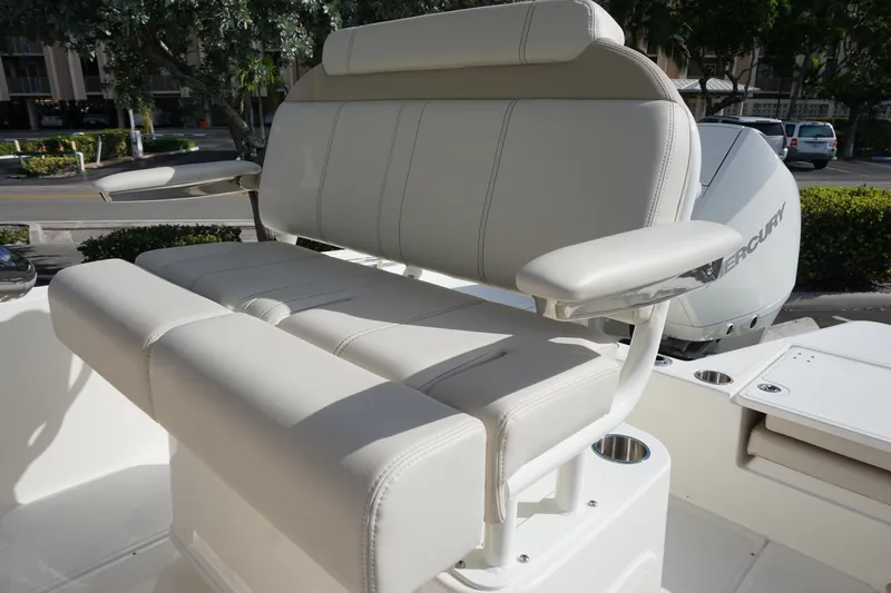Slide: The Image of 2026 Boston Whaler 220 Dauntless boat seat with armrests, outdoor setting. - 19