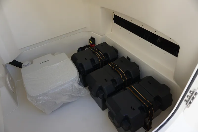 Slide: The Image of 2026 Boston Whaler 220 Dauntless interior storage with battery compartments and equipment. - 24