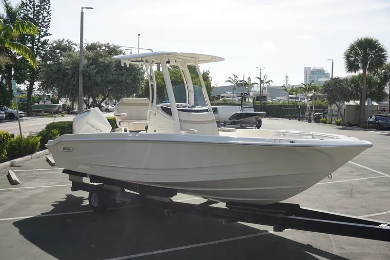 Slide: The Image of 2026 Boston Whaler 220 Dauntless boat on trailer in sunny parking lot. - 5