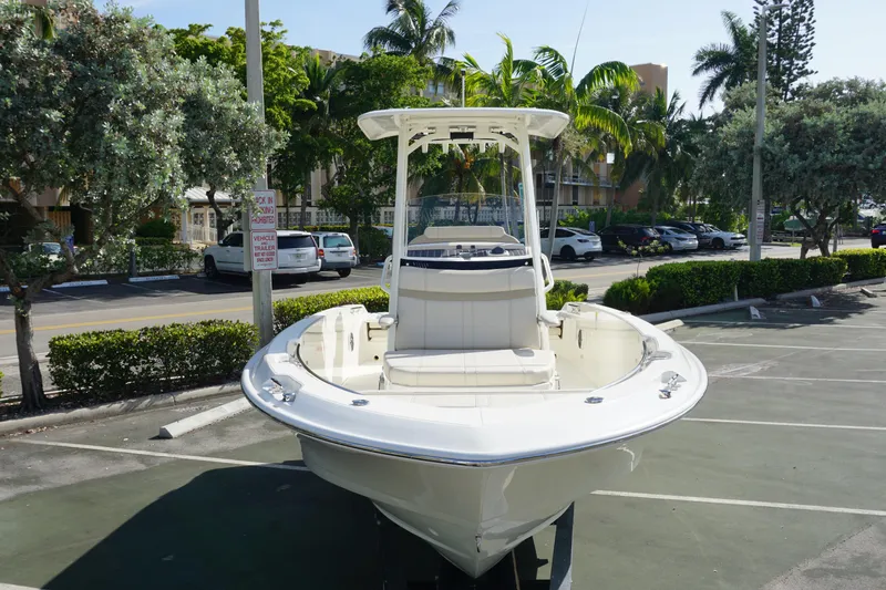 Slide: The Image of 2026 Boston Whaler 220 Dauntless boat parked in a sunny lot with palm trees. - 6