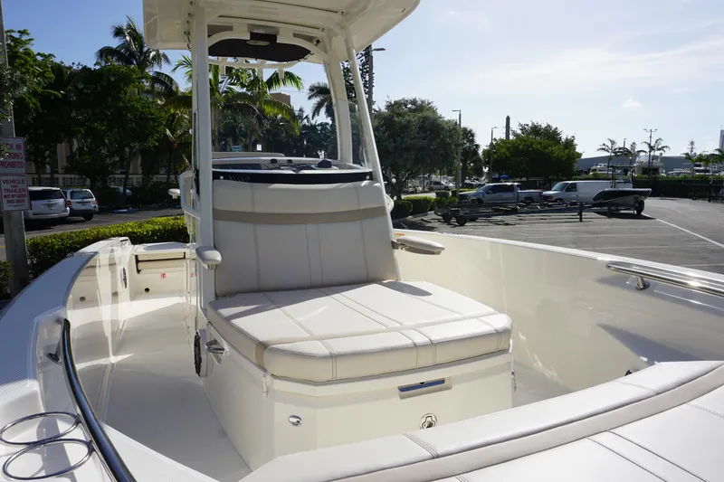 Slide: The Image of 2026 Boston Whaler 220 Dauntless boat interior with seating, parked in a sunny marina. - 9