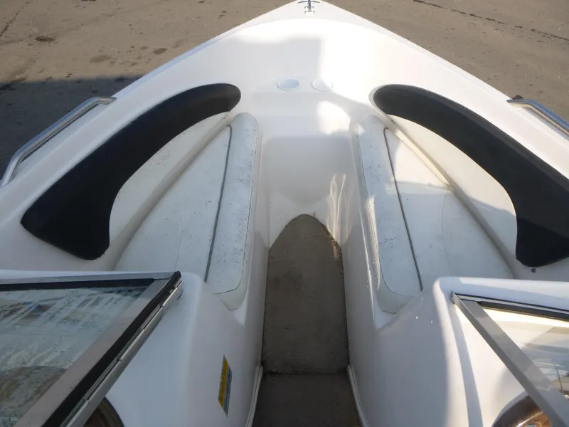 Slide: The Image of 2003 Rinker 180 BR boat interior with white seating and black accents. - 12