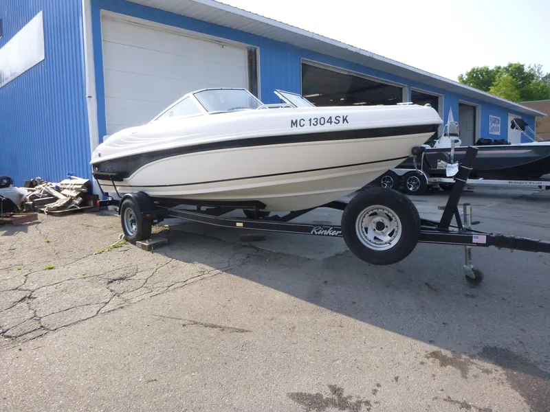 Slide: The Image of 2003 Rinker 180 BR boat on trailer outside blue building. - 3