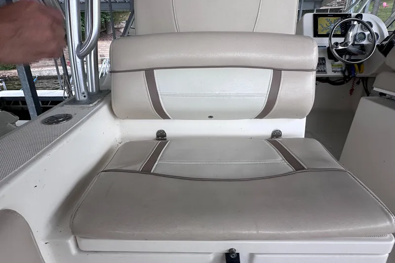 Slide: The Image of 2013 World Cat 255 DC boat interior with beige seating and steering wheel. - 12