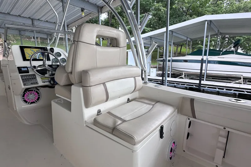 Slide: The Image of Interior of a 2013 World Cat 255 DC boat with beige seating and control panel. - 13