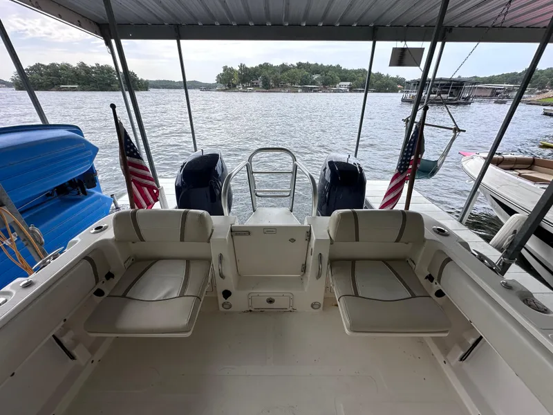 Slide: The Image of 2013 World Cat 255 DC boat interior with seating, docked by a scenic lake. - 15