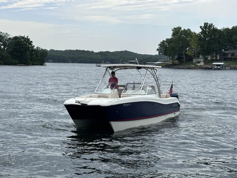 Slide: The Image of 2013 World Cat 255 DC boat cruising on a lake with scenic shoreline. - 20