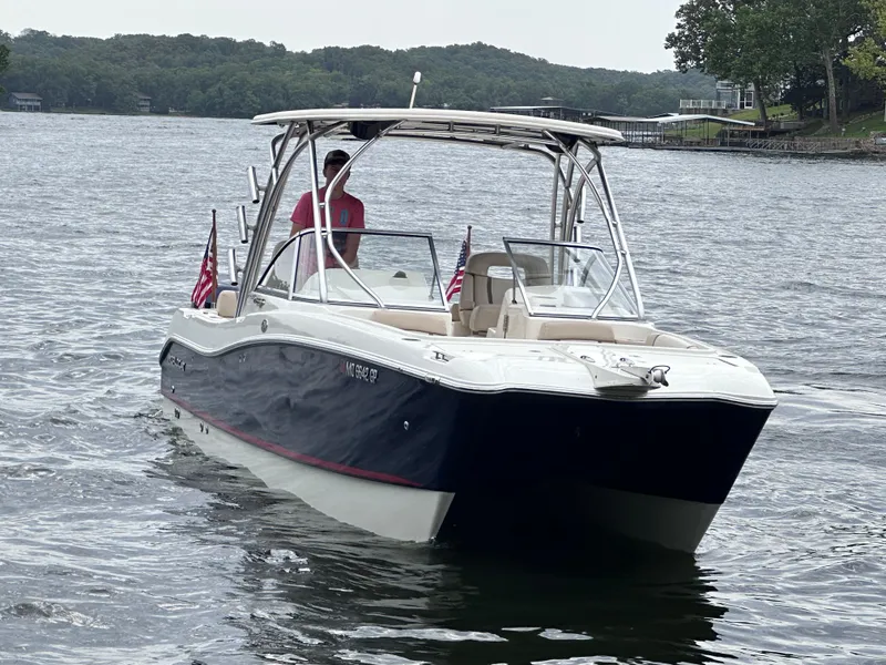 Slide: The Image of 2013 World Cat 255 DC boat cruising on a lake with American flags. - 22