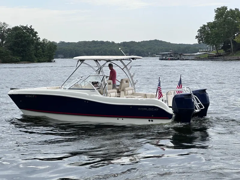Slide: The Image of 2013 World Cat 255 DC boat cruising on a lake with American flags. - 24