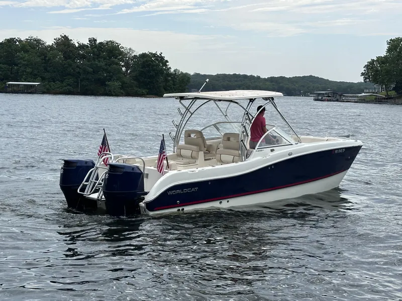 Slide: The Image of 2013 World Cat 255 DC boat cruising on a lake with American flags. - 25