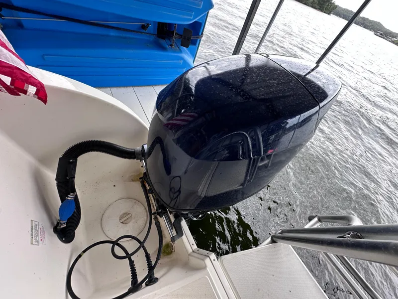 Slide: The Image of 2013 World Cat 255 DC boat engine by the water, docked with visible ladder. - 27