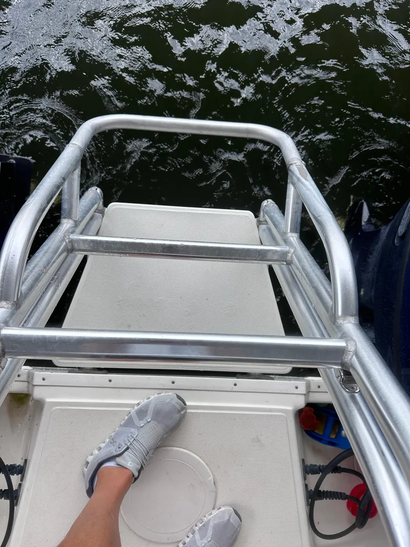 Slide: The Image of Person standing on a 2013 World Cat 255 DC boat platform above water. - 29