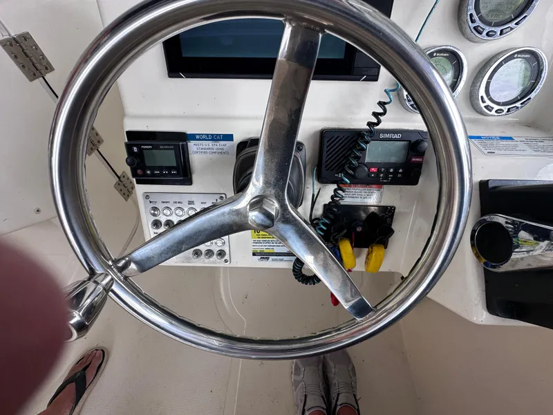 Slide: The Image of Steering wheel and controls of a 2013 World Cat 255 DC boat cockpit. - 4