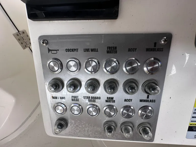 Slide: The Image of Control panel of a 2013 World Cat 255 DC boat with labeled switches and buttons. - 7