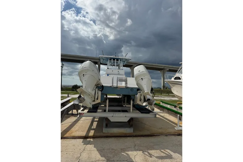 Slide: The Image of 2021 Twin Vee 280 CC GF boat with dual outboard motors on a lift. - 20