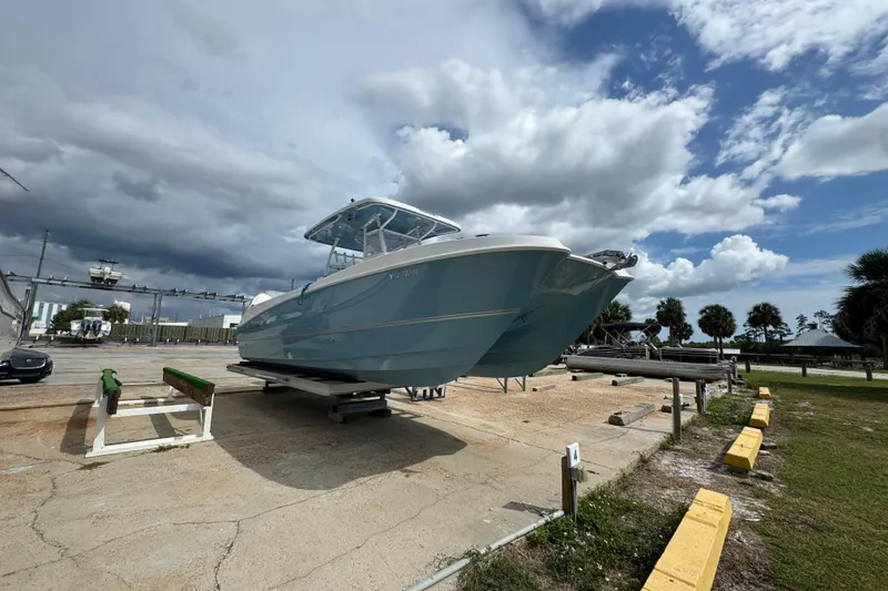 Slide: The Image of 2021 Twin Vee 280 CC GF boat on a trailer under a cloudy sky. - 23