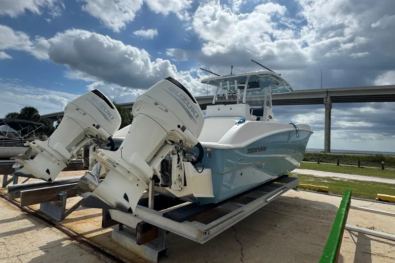 Slide: The Image of 2021 Twin Vee 280 CC GF boat with dual Suzuki outboard motors on a trailer. - 34