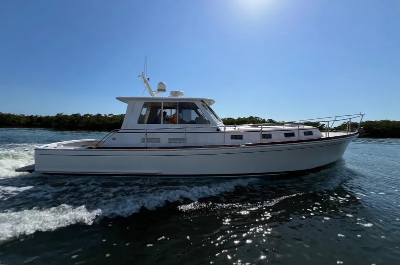 Slide: The Image of 2002 Grand Banks 43 Eastbay HX cruising on water under clear blue sky. - 0