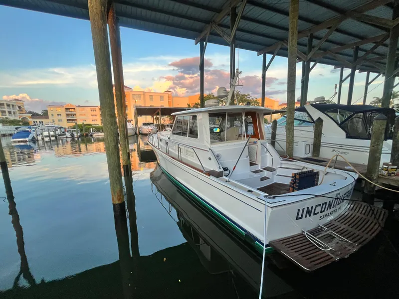 Slide: The Image of 2002 Grand Banks 43 Eastbay HX docked in a marina at sunset. - 10