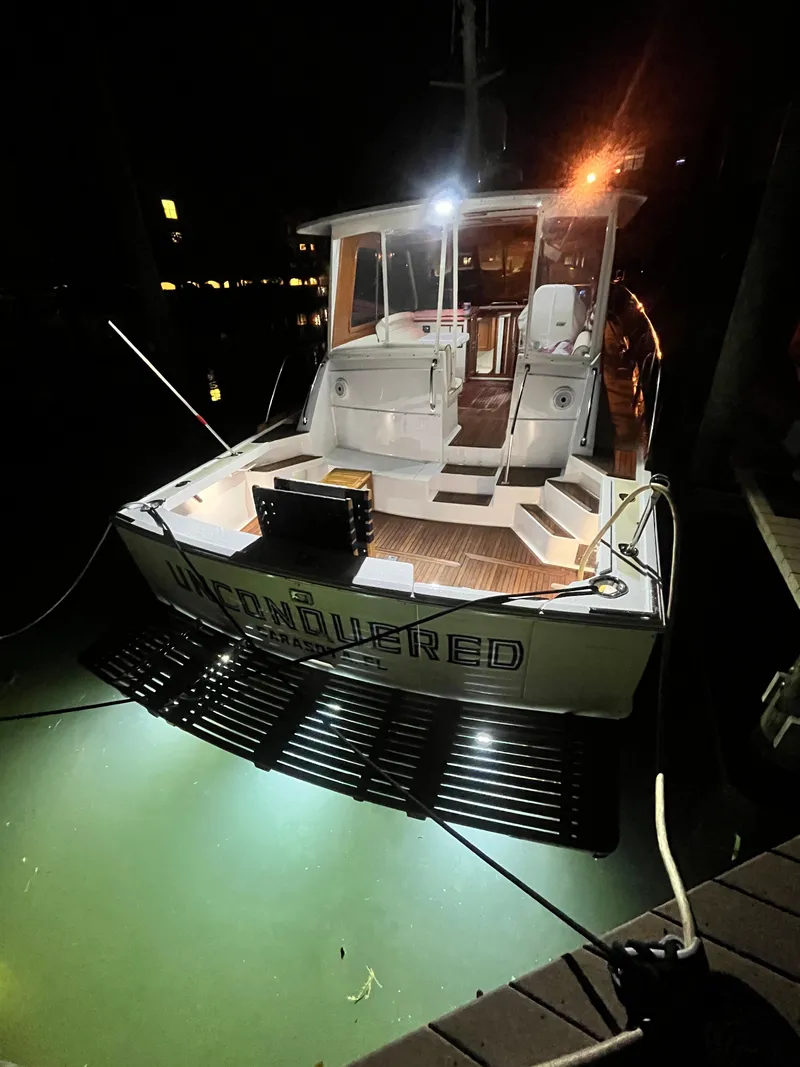 Slide: The Image of 2002 Grand Banks 43 Eastbay HX yacht illuminated at night, docked with underwater lights. - 18