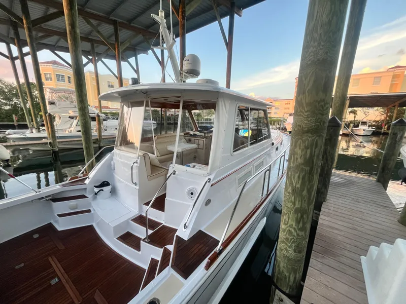 Slide: The Image of 2002 Grand Banks 43 Eastbay HX docked under a covered marina, showcasing elegant design. - 20