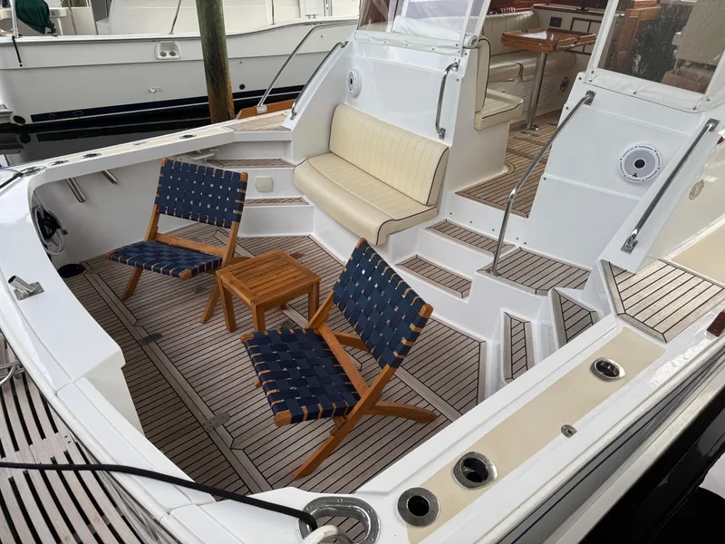 Slide: The Image of 2002 Grand Banks 43 Eastbay HX yacht with teak deck, seating area, and wooden chairs. - 21