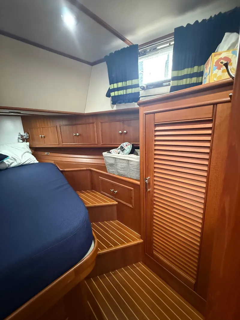 Slide: The Image of Cozy cabin interior of 2002 Grand Banks 43 Eastbay HX with wooden furnishings and blue bedding. - 28